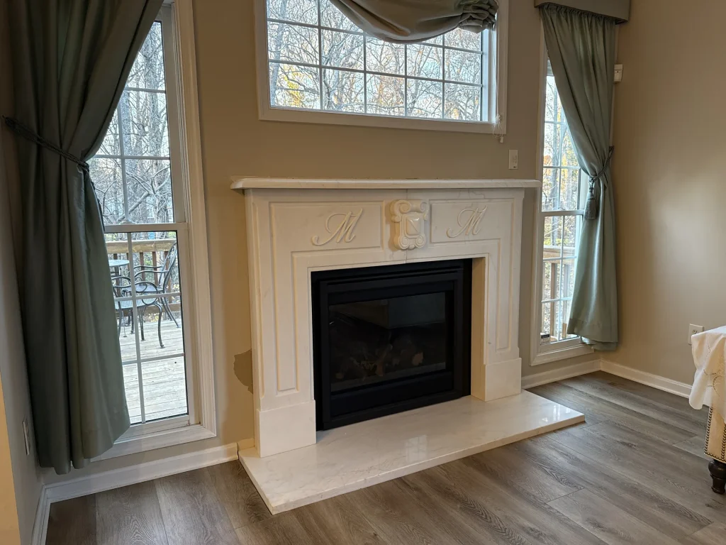 Gas fireplace in a carved marble mantel in a bright living room, a Hearthbeats project in Montgomery County, Maryland