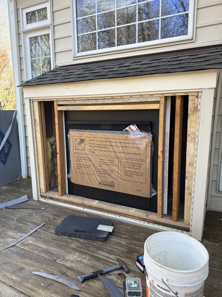 A new fireplace unit set into a framed rough opening during installation, planning stage of a Hearthbeats project